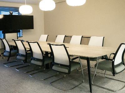 Ton vormige vergadertafel met vergaderstoelen en drie mooie hanglampen