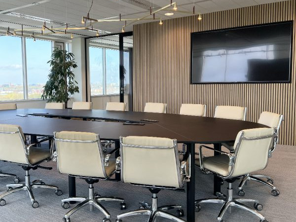 Vergaderruimte inrichting met een grote design vergadertafel met zwart blad en beige vergaderstoelen
