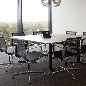 Vergaderruimte inrichting met een vierkante vergadertafel in minimalistische setting met Vitra vergaderstoelen