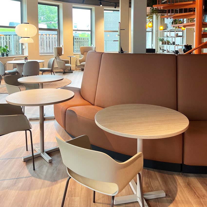 Kantine inrichting met ronde banken en kolomtafels